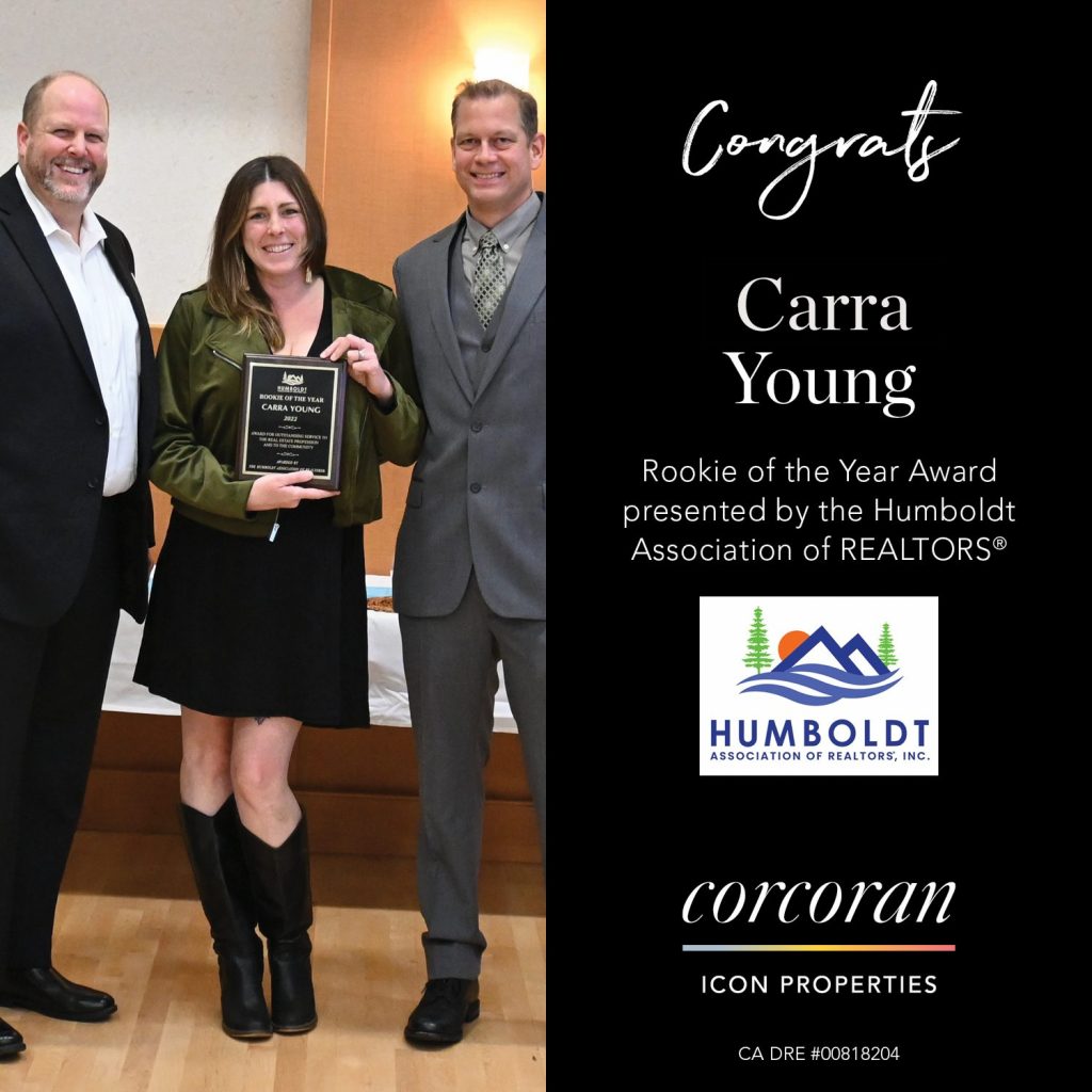 Three people posing for photo with one receiving award.