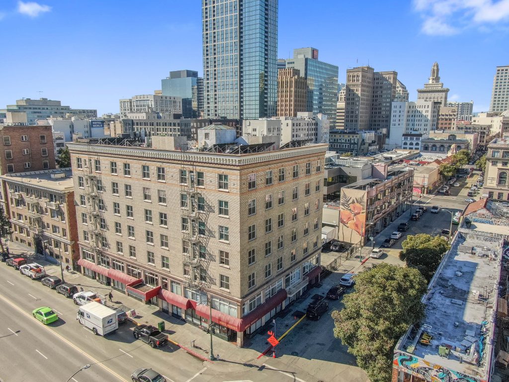 image of city with large buildings in the background and a large brick hotel in the foreground